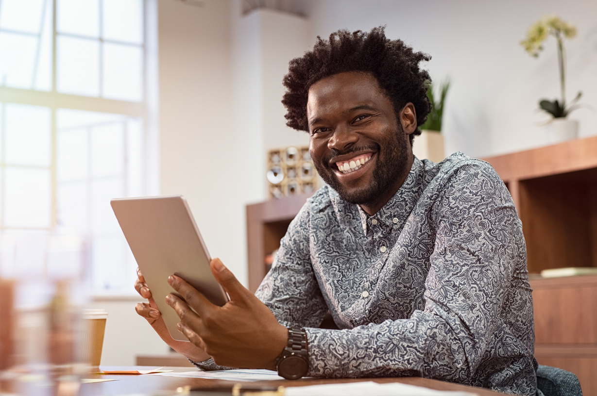 Smiling Businessman Holding a Tablet in the Office